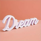 White decorative word 'Dream' on a peach background