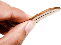 Hand holding a small cork product against a white background