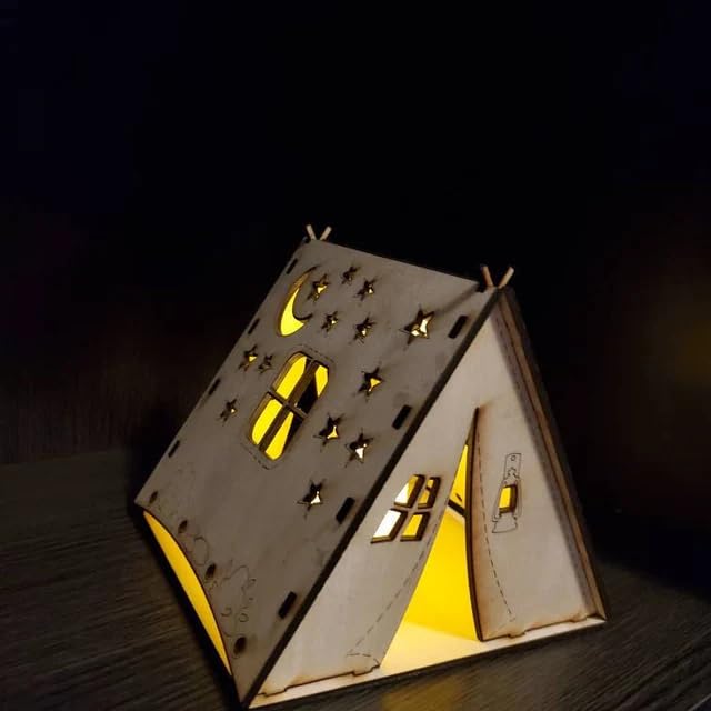 Wooden house-shaped lamp with cut-out windows and door on a dark background
