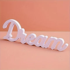 White decorative word 'Dream' on a peach background
