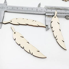 Wooden feather-shaped cutouts with a ruler for scale on a white background