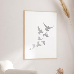 Framed artwork of birds on a white wall in a minimalistic room.