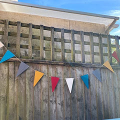 Colorful triangular flags hanging on a wooden fence with a blue sky background