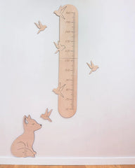 Wooden growth chart with animal illustrations on a white wall