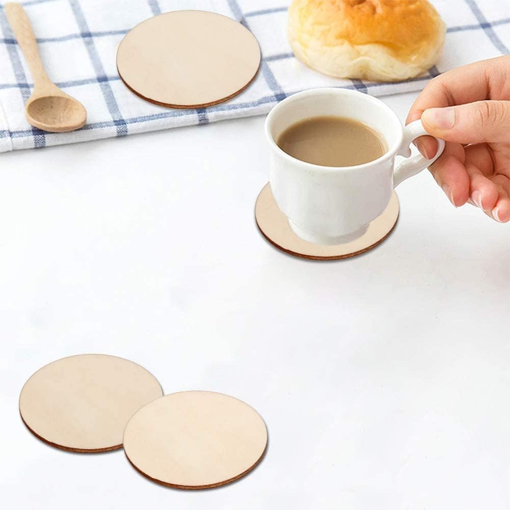 Person holding a cup of coffee on a wooden coaster with other coasters and bread in the background.
