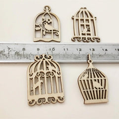 Four wooden birdcage-shaped decorations with a ruler for scale on a white background