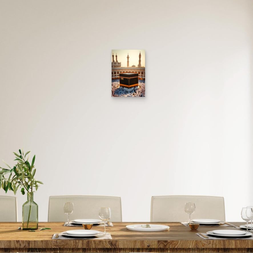 Dining room with a table set for four, a vase with plants, and a wall art of the Kaaba.
