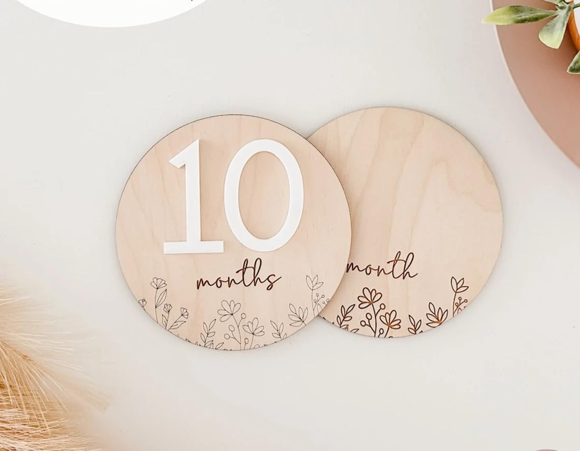Two wooden circular plates with '10 months' and '9 months' text on a light background.