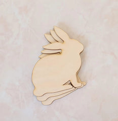 Wooden rabbit cutout on a light pink background
