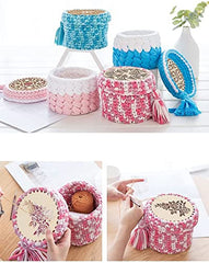 Decorative woven stools with tassels in various colors on a white surface.