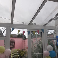 Clear glass conservatory with colorful bunting and decorative lanterns.