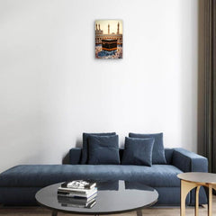 Modern living room with a blue sofa, round coffee table, and wall art of the Kaaba.