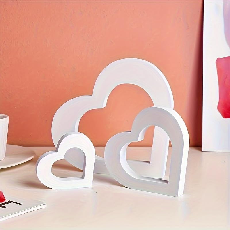 Set of white heart-shaped objects on a pink surface with a coral wall background