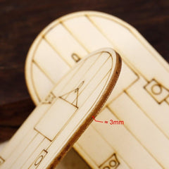 Close-up of a laser-cut wooden model airplane with dimensions indicated.