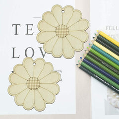 Two flower-shaped cutouts on a piece of paper with colored pencils on a white background.