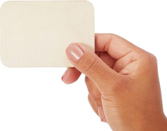 Hand holding a beige square swatch against a white background