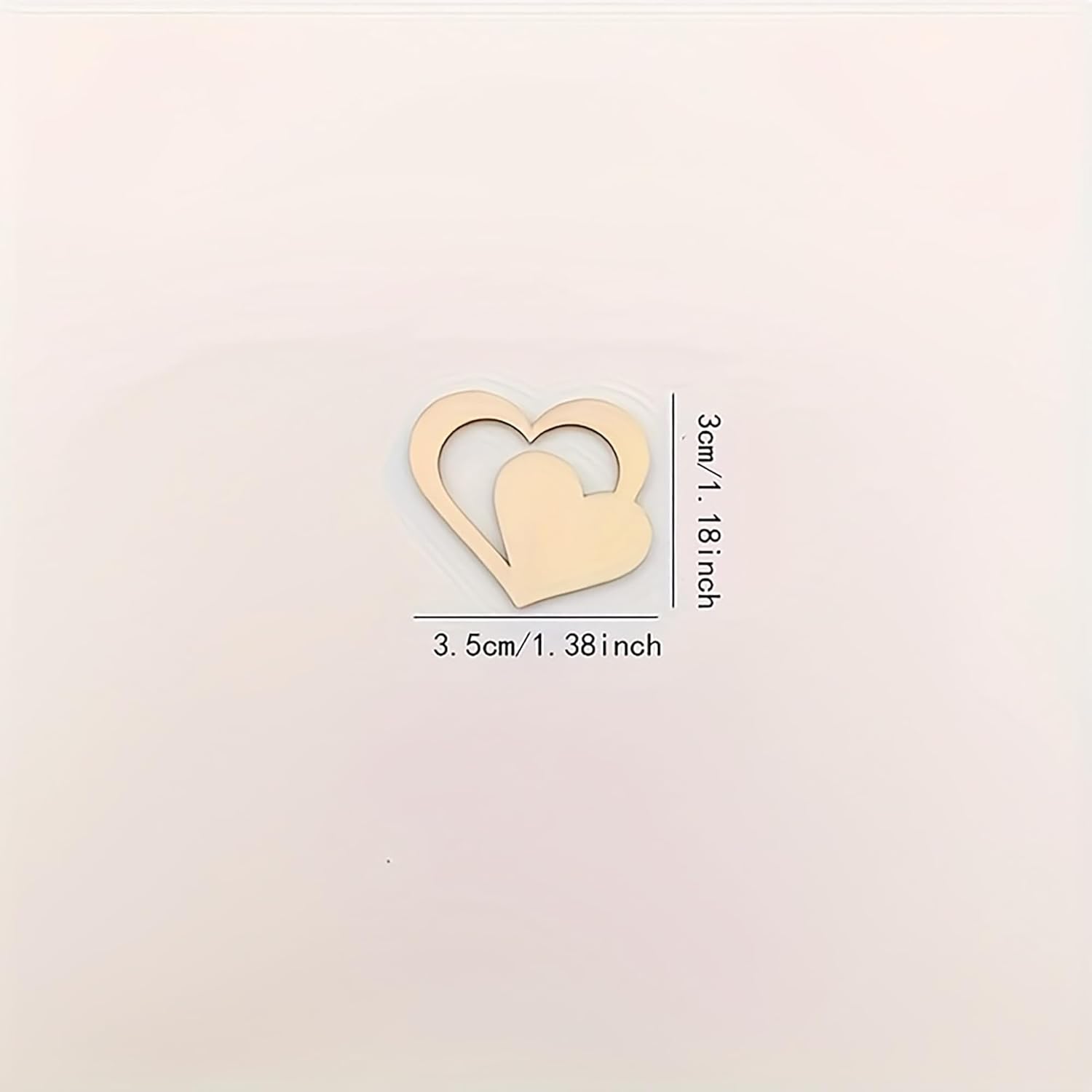 Gold heart-shaped object with measurements on a beige background