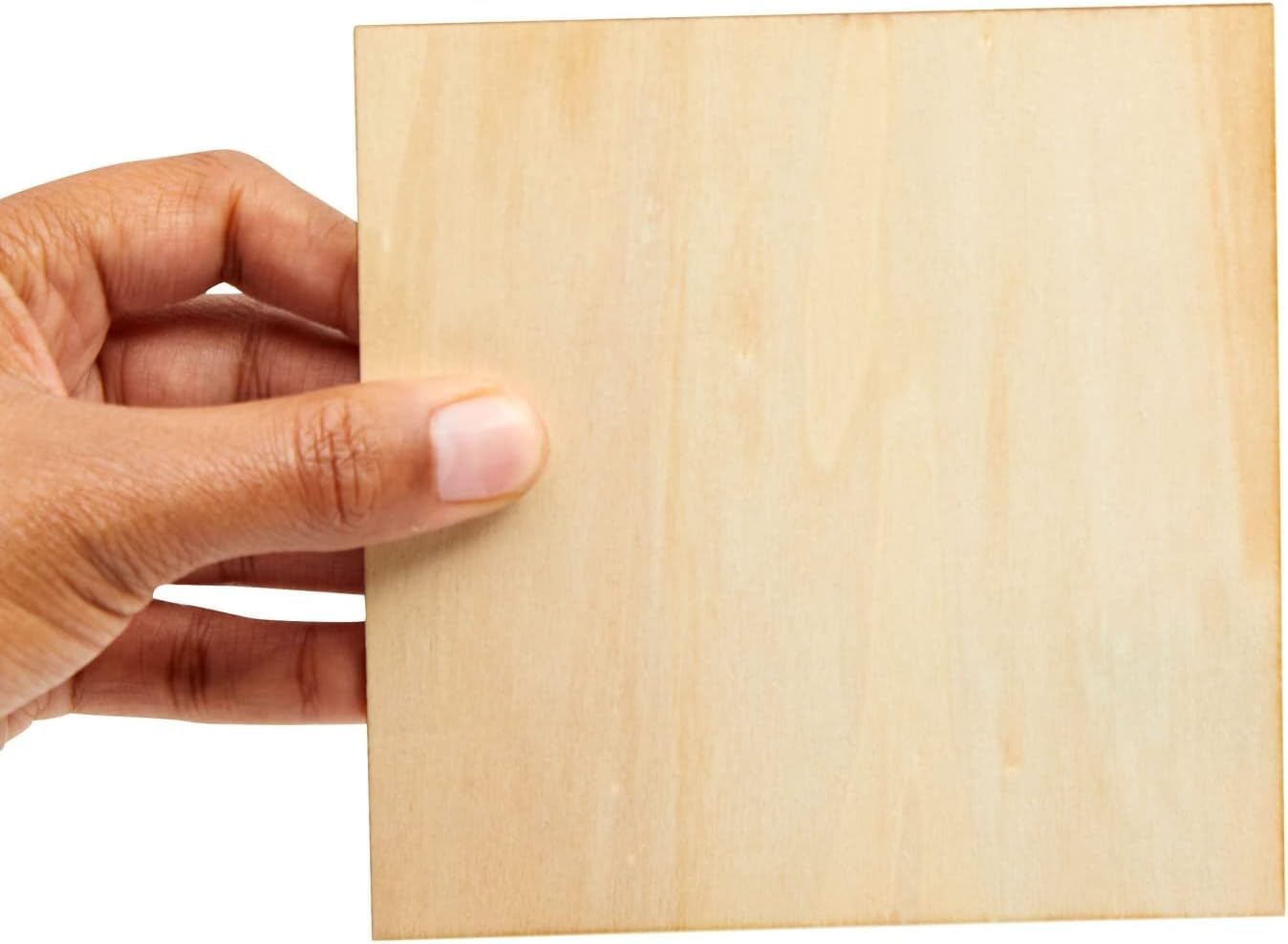 Hand holding a piece of light-colored wood against a white background