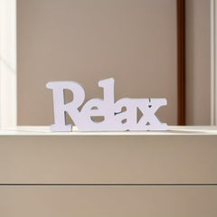 White 'Relax' sign on a beige surface