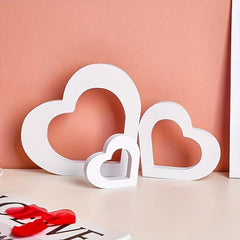 White heart-shaped decor pieces on a pink background