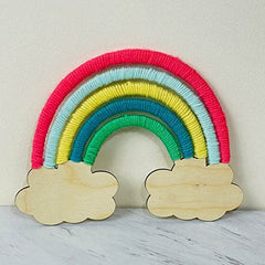 Colorful yarn rainbow with wooden cloud shapes on a light background