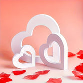 White heart-shaped objects on a pink background with red petals