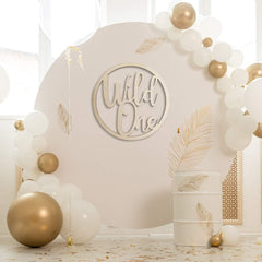 Decorative arch with 'Wild One' sign and balloons in a bright room