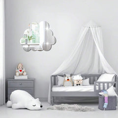 Children's bedroom with a gray crib, stuffed animals, and a decorative mirror.
