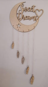 Decorative wall hanging with 'Sweet Dreams' text on a moon shape, featuring feathers and a star.