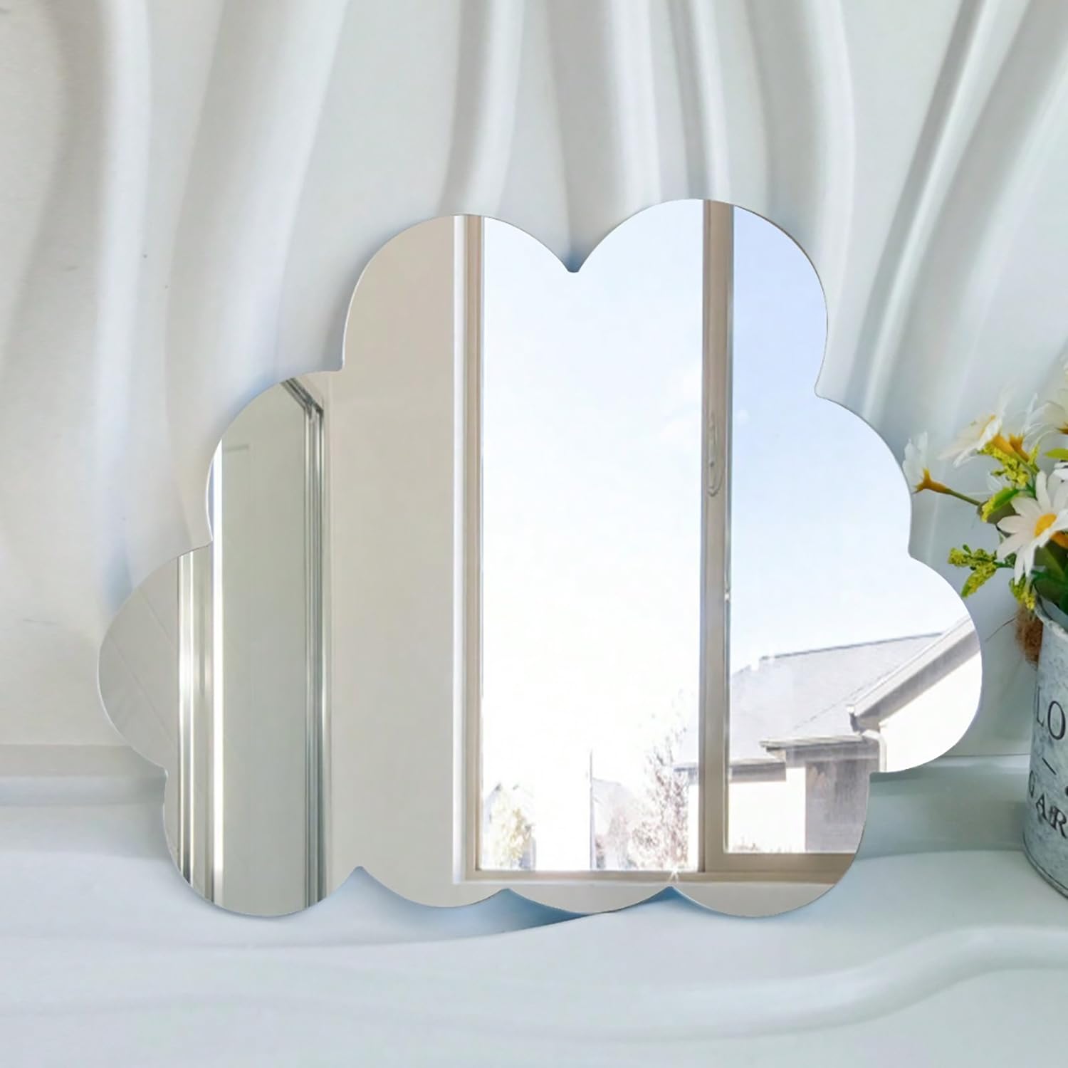 Decorative wall mirror with a cloud design on a white surface.