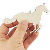 Wooden horse-shaped ornament held in a hand against a white background