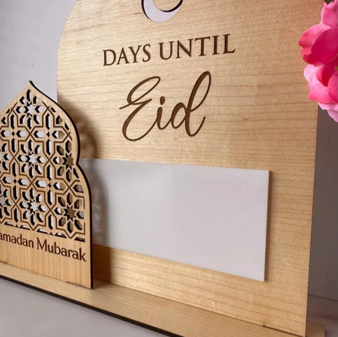 Wooden countdown to Eid holder with decorative elements on a neutral background