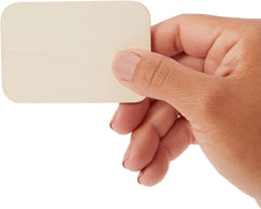 Hand holding a beige square object against a white background