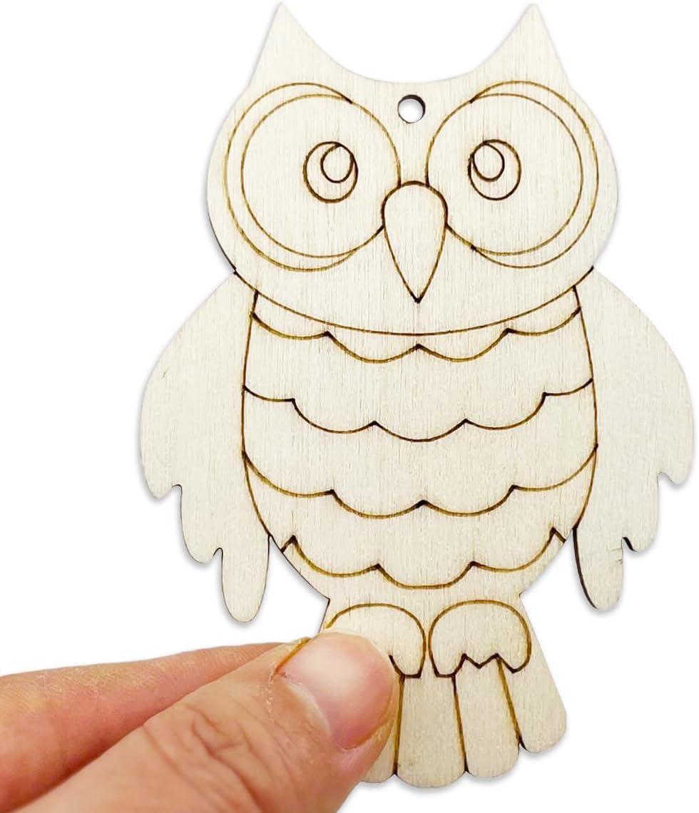 Wooden owl ornament held by a hand on a white background