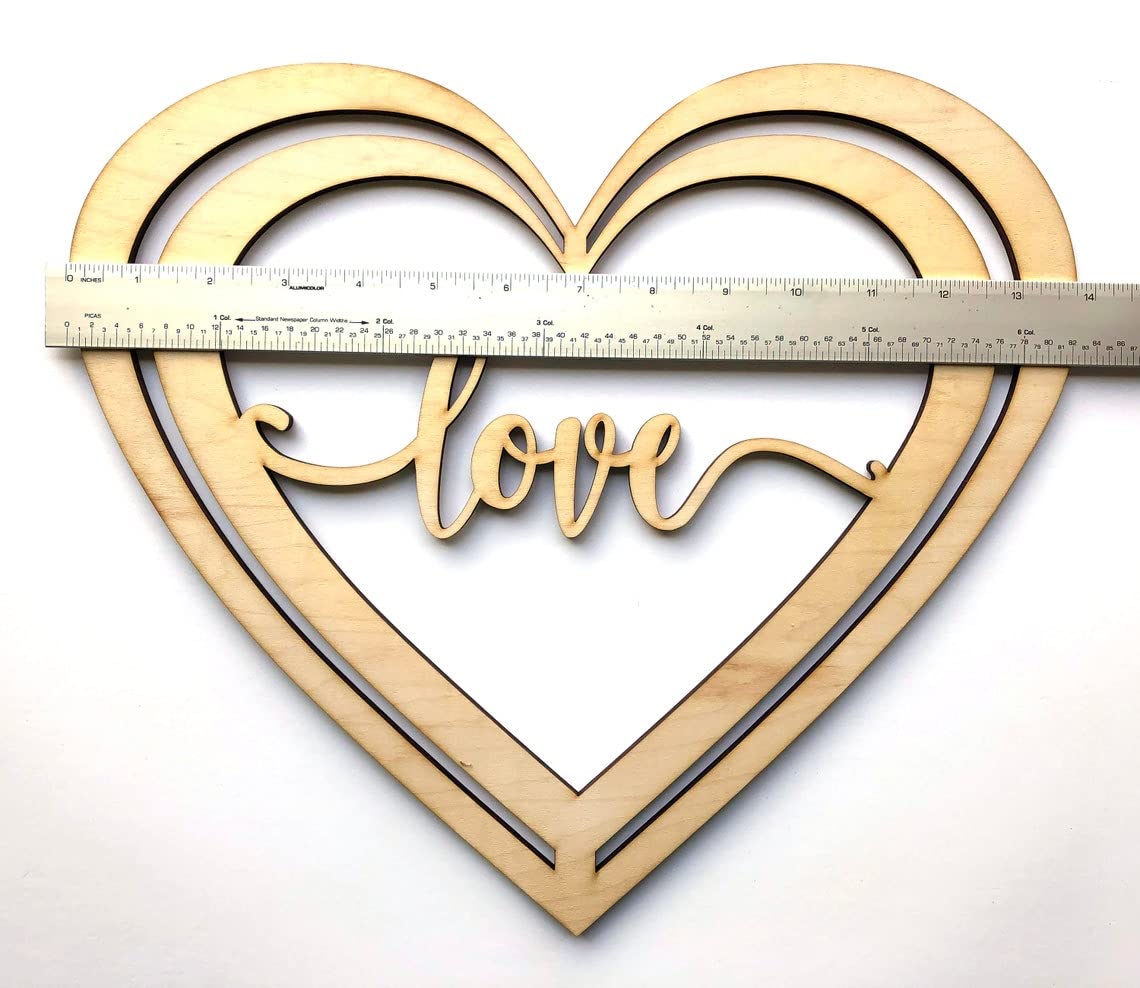 Wooden heart-shaped cutout with 'love' text and a ruler for scale on a white background