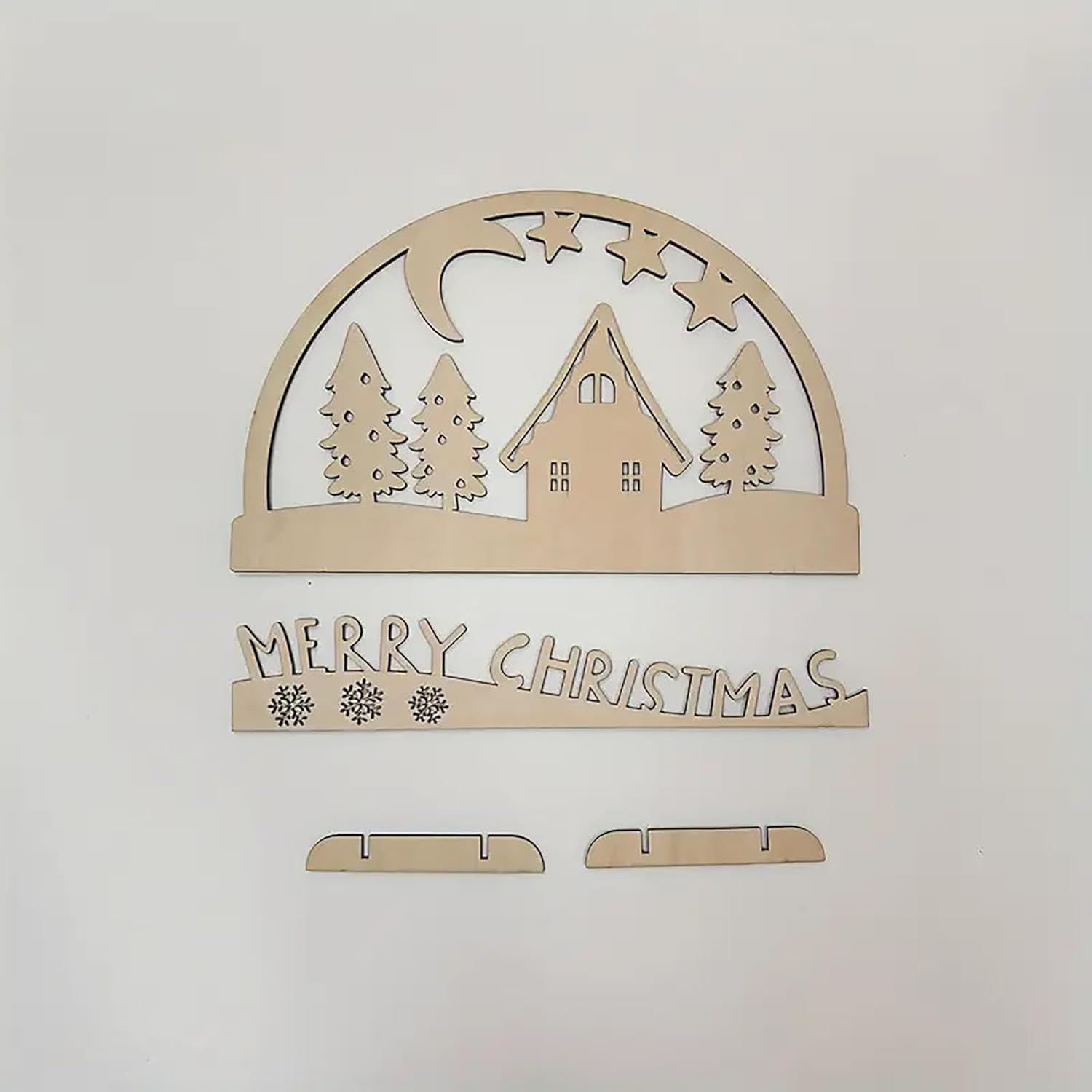Wooden Christmas decoration with house, trees, and 'Merry Christmas' text on a light gray background