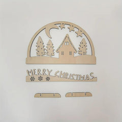 Wooden Christmas decoration with house, trees, and 'Merry Christmas' text on a light gray background