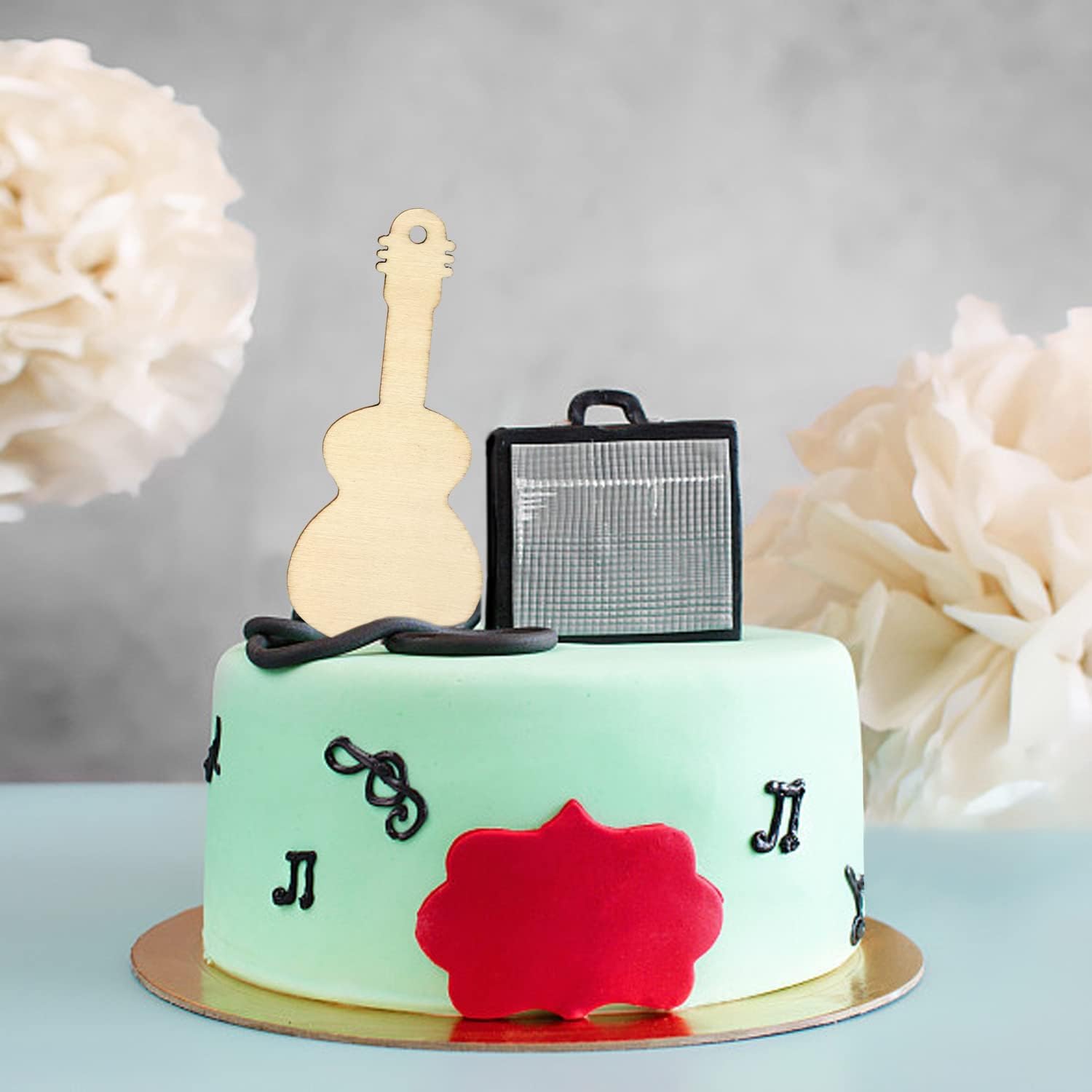 Cake with guitar and microphone decorations on a light background
