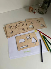 Wooden shape sorting toys on a white surface with pencils and a small figurine.