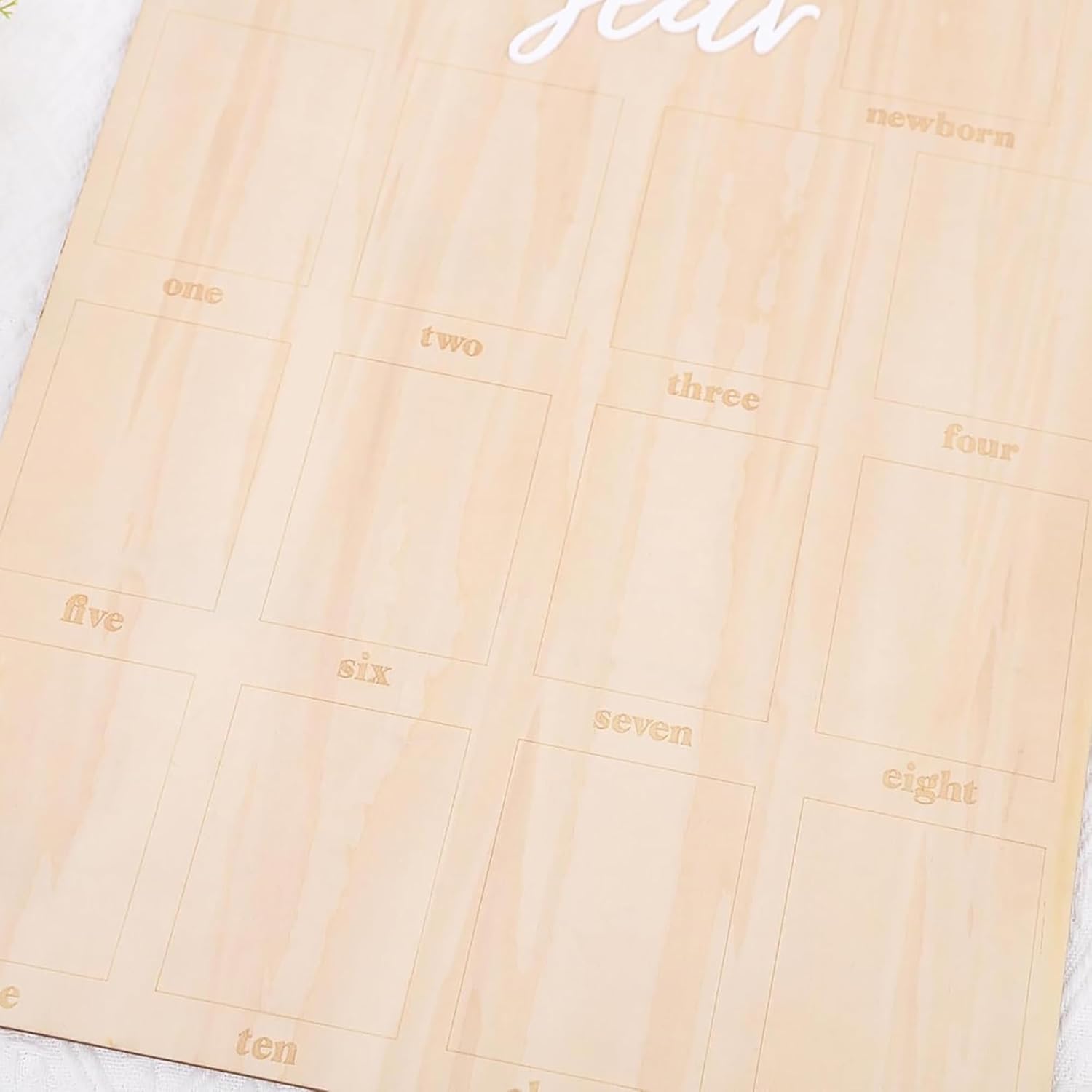 Wooden growth chart with numbers and 'newborn' text on a light wood background