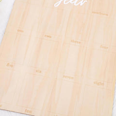 Wooden growth chart with numbers and 'newborn' text on a light wood background