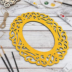Yellow decorative frame on a wooden surface with painting supplies.