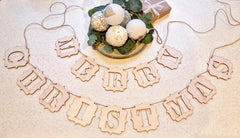 Wooden 'Merry Christmas' sign with decorative ornaments on a light background