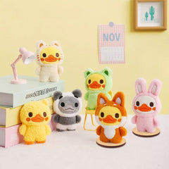 Set of colorful plush toys on a white surface with a yellow wall background