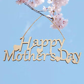 Wooden 'Happy Mother's Day' sign with cherry blossoms against a blue sky