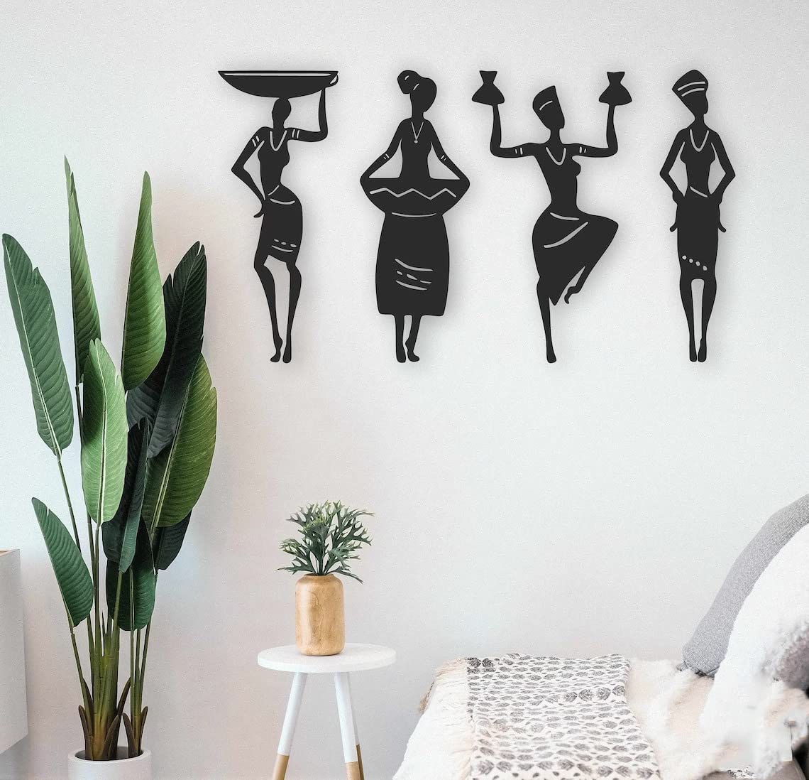 Decorative wall art of black silhouettes of women on a white wall.