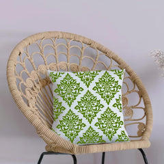 Wicker chair with a green and white patterned pillow on a light background