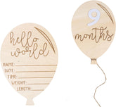 Two wooden balloons with 'hello world' and '9 months' inscriptions on a white background.