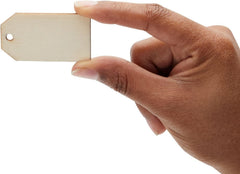Hand holding a small wooden tag against a white background