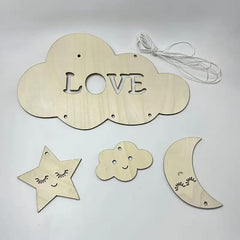 Wooden cloud-shaped decoration with 'LOVE' letters, star, cloud, and moon shapes on a light gray background.